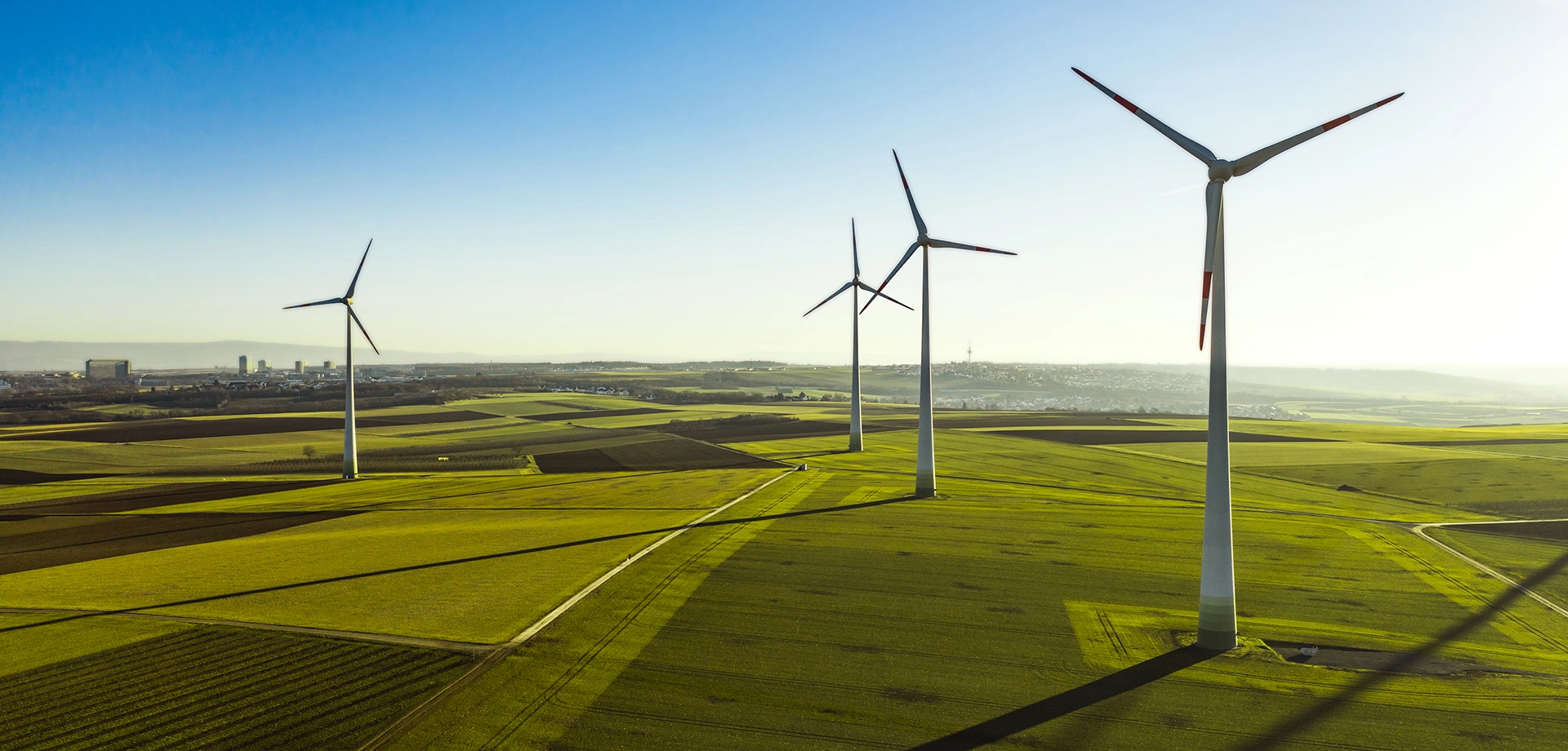 Several windmills on a green landscape.