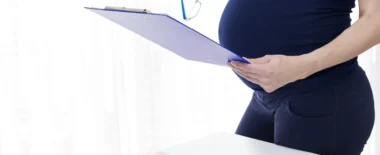 Pregnant worker holding a clipboard